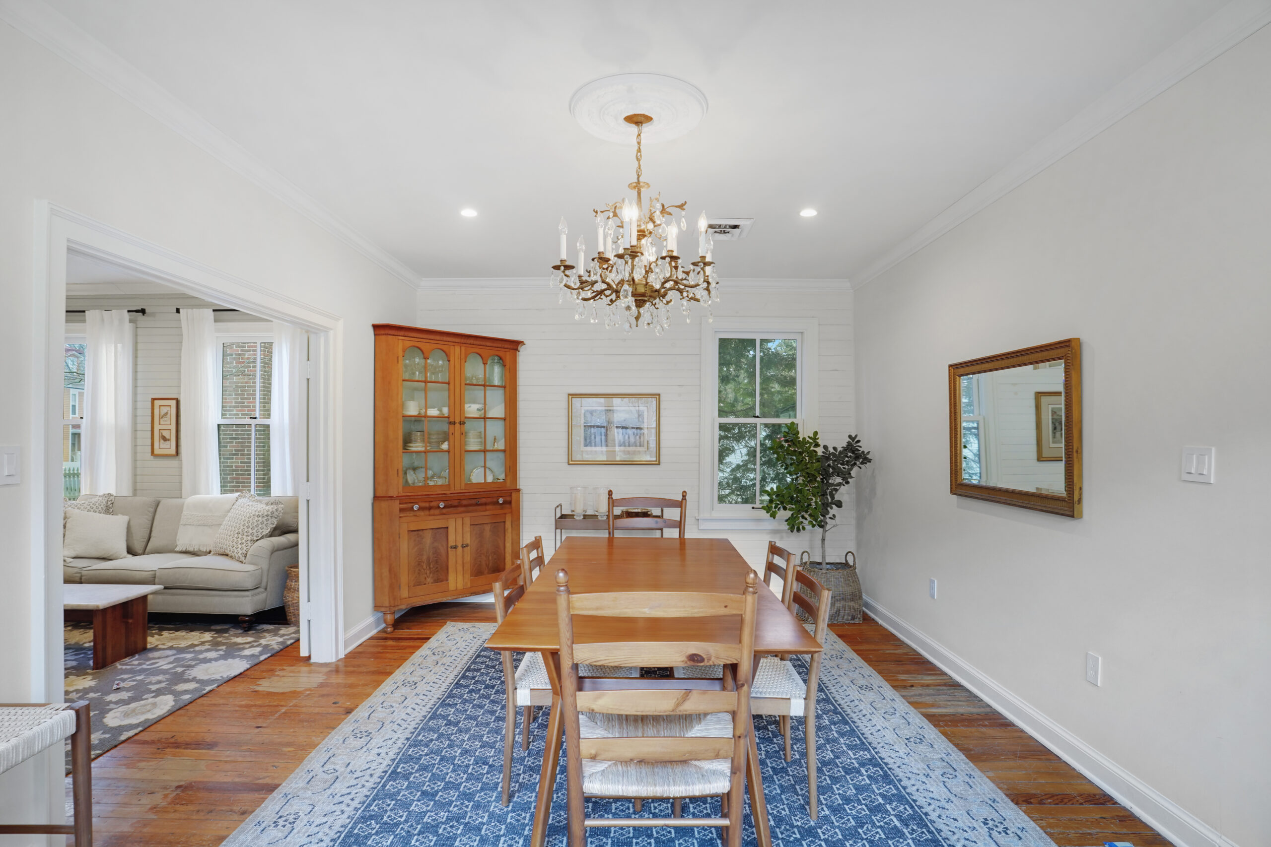 Airy dining area with chandelier and hardwood floor